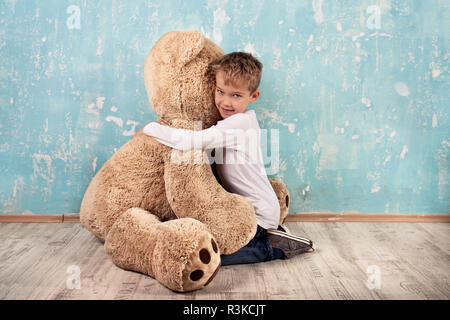 Kind Kuscheln mit Teddybär Stockfoto