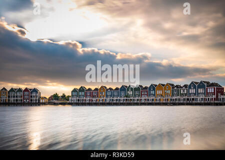 Niederländisch, modernen, farbenfrohen vinex Architektur Häuser am Wasser während der dramatischen und bewölkt, Sonnenuntergang. Houten, Utrecht. Stockfoto