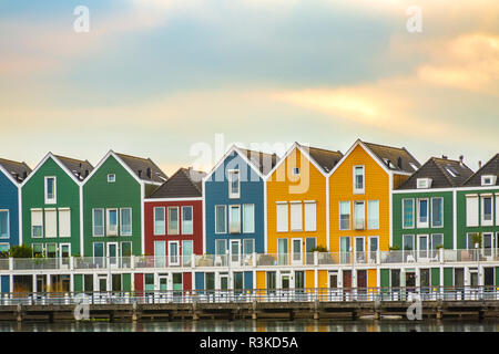 Niederländisch, modernen, farbenfrohen vinex Architektur Häuser am Wasser während der dramatischen und bewölkt, Sonnenuntergang. Houten, Utrecht. Stockfoto