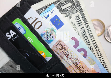 Pfund, Euro, US-Dollar, Kredit- und Kundenkarten in einem britischen Wallet. Stockfoto