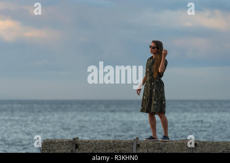 Wladiwostok, Russia-August 26, 2018: süße Mädchen auf dem Hintergrund der Meer den Sonnenuntergang bewundert Stockfoto