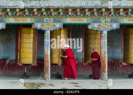 Pilger, die sich drehenden Gebetsmühlen, Tagong Kloster, Tagong, Western Sichuan, China Stockfoto