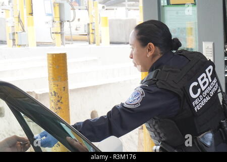 Einer US-amerikanischen Zoll- und Grenzschutz Agent gibt die Identifikation zu einem Treiber die Einreise in die Vereinigten Staaten von Mexiko im San Ysidro 22. November, 2018 Kreuzung in San Ysidro, Kalifornien. Stockfoto