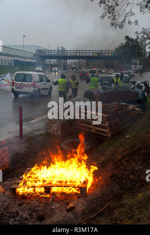 La Biolle, Auvergne-Rh ône-Alpes, Frankreich. 23. November 2018. Aktivisten der "Gilet Jaune 'nationalen Protestbewegung nehmen Sie teil an der "Operation Peage Wwe Smackdown Vs Raw" (freier Autobahn) an einer Ausfahrt der Autobahn A41 in der Nähe von La Biolle in der Auvergne-Rh ône-Alpes region in Frankreich. Die 'Gilet Jaune'-Kampagne gegen Unterdrückung in der Besteuerung, insbesondere motorisch Steuern auf Treibstoff etc. Credit: Graham M. Lawrence/Alamy leben Nachrichten Stockfoto