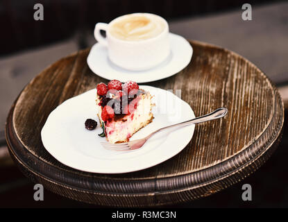 Köstliches Dessert auf Braun strukturierten Hintergrund. Patisserie Konzept. Stück Kuchen mit Brombeeren und Himbeeren in der Nähe von heißen Getränk. Käsekuchen mit Stockfoto
