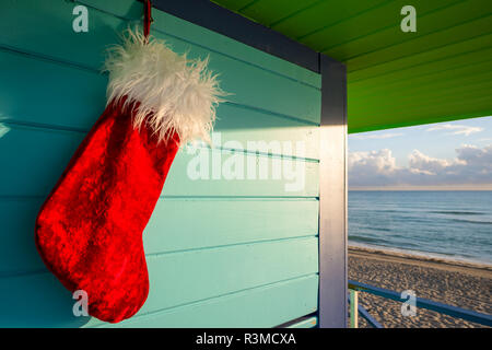 Santa stocking Weihnachten Dekoration hängen von bunten lifeguard Tower nächste Tropical Seas in Miami Beach, Florida, USA zu beruhigen Stockfoto
