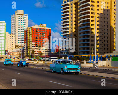 Havanna, Kuba, drei klassische alte blaue Autos entlang der Malecon Autobahnfahrten mit bunten Gebäude im Hintergrund Stockfoto