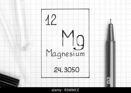 Das Periodensystem der Elemente. Handschrift chemische Element Magnesium Mg mit schwarzem Stift, Reagenzglas und Pipette. Close-up. Stockfoto