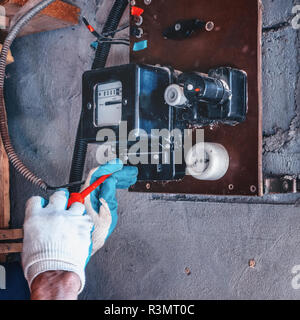 Austausch der alten Stromzähler mit einem Neuen. Reparatur von elektrischen Ausrüstungen Stockfoto