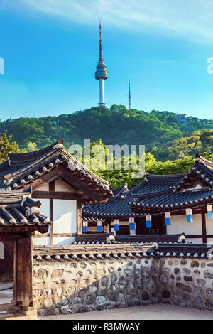 Seoul, Südkorea. Traditionelle koreanische Dorf Innenhof von Namsangol Hanok mit dem YTN Seoul Tower (Namsan Tower oder Seoul Tower) im Hintergrund. Stockfoto
