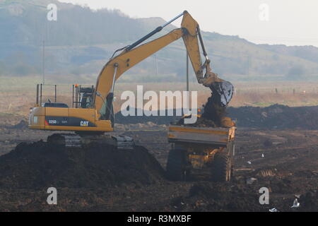 Ein Caterpillar 325 Tieflöffel loading Dump Trucks auf den Bau von Iport in Rossington, Doncaster. Stockfoto