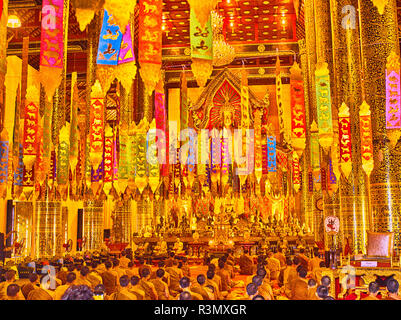 Thailand, Chiang Mai, Wat Chedi Luang in Chiang Mai mit Bändern drapieren von der Decke und Mönche beten Stockfoto