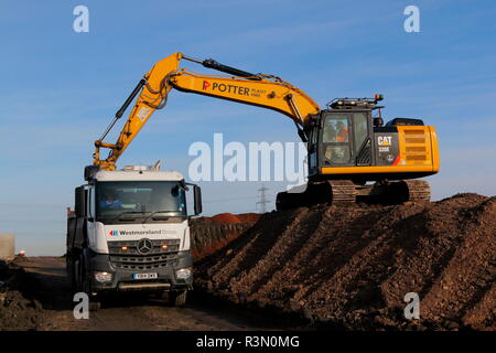 Ein Caterpillar 320E Beladen von Lkws auf der FARRRS Link Road in Rossington, Doncaster, die jetzt als die großen Yorkshire Weise bekannt Stockfoto