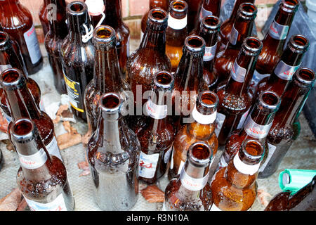 Leere Bierflaschen links sitzt auf dem Bürgersteig vor einem Haus Stockfoto
