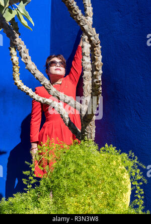 Chinesische Touristen im roten Kleid posiert im Jardin Majorelle Garten, Marrakesch (Marrakesch), Marokko Stockfoto