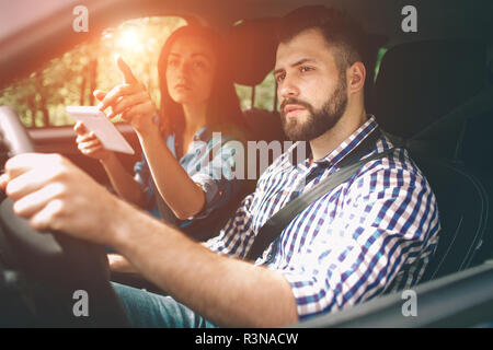 Paar mit gps auf Tablet compter im Auto in den Urlaub zu navigieren. Stockfoto