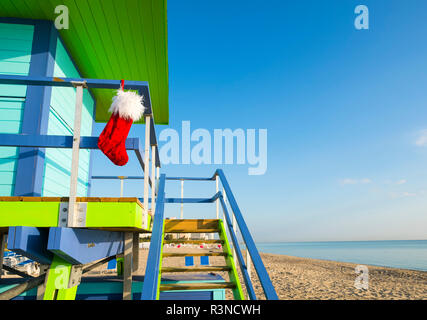 Santa stocking Weihnachten Dekoration hängen von bunten lifeguard Tower nächste Tropical Seas in Miami Beach, Florida, USA zu beruhigen Stockfoto