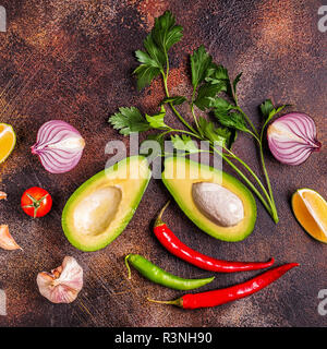 Zutaten für Guacamole: Avocado, Kalk, Tomaten, Zwiebeln und Gewürzen, Ansicht von oben. Stockfoto