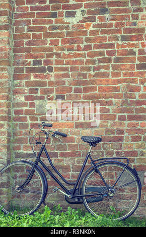 Bycycle gegen eine alte Mauer geparkt Stockfoto