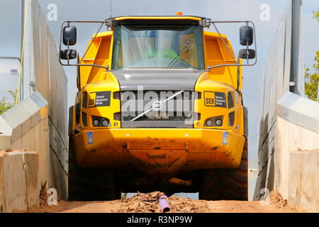 Ein Knickgelenkter Dumper drückt durch die schmale Brücke über die Eisenbahn auf dem Bau von Iport in Rossington, Doncaster, South Yorkshire Stockfoto