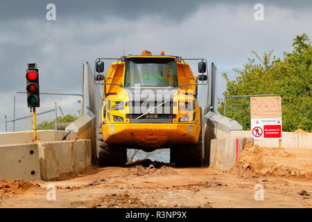 Ein Knickgelenkter Dumper drückt durch die schmale Brücke über die Eisenbahn auf dem Bau von Iport in Rossington, Doncaster, South Yorkshire Stockfoto