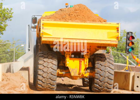 Ein Knickgelenkter Dumper drückt über einem schmalen Eisenbahnbrücke über den Bau von Iport in Rossington, Doncaster, South Yorkshire. Stockfoto