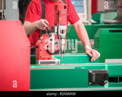 Der Mensch arbeitet auf die automatisierte CNC-Ausrüstung für die Arbeit mit Metall. Die programmierte Roboter Kopf. Stockfoto