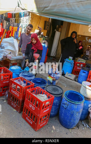 Eine Frau ladling oder gießen Milch in eine Flasche mit einem Mann, der die Daumen oben unterzeichnen am lokalen Markt in Edfu, Ägypten, Nordafrika Stockfoto