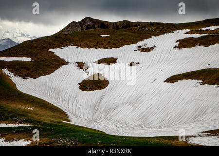 Weiße Schneeflecken sind auf dem Gurnigel Pass in der Schweiz zu sehen. Die Gletscher in den Alpen schmelzen aufgrund der globalen Erwärmung schnell, und viele von ihnen werden voraussichtlich bis 2070 verschwunden sein. Die weiße Schneedecke reflektiert das Sonnenlicht und die Hitze viel besser als das dunklere Eis. Im Winter 2017/2018 gab es in den alpen Rekordschneemengen, aber die Rekordtemperaturen im Sommer schmolzen den größten Teil bereits im Juni. Stockfoto