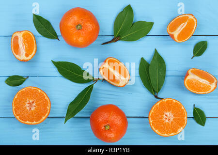 Orange oder Mandarine mit Blättern auf Blau Holz- Hintergrund. Flach, Ansicht von oben. Obst Zusammensetzung Stockfoto