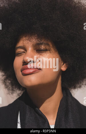 Frau mit Augen an einem sonnigen Tag geschlossen Stockfoto