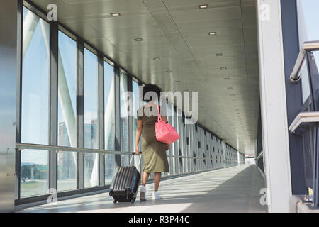 Frau mit Gepäck Tasche wandern am Flughafen Stockfoto