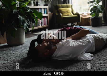 Paar entspannende auf dem Fußboden im Wohnzimmer. Stockfoto