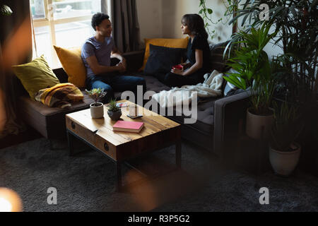 Paar interagieren, während Sie Kaffee auf dem Sofa im Wohnzimmer. Stockfoto