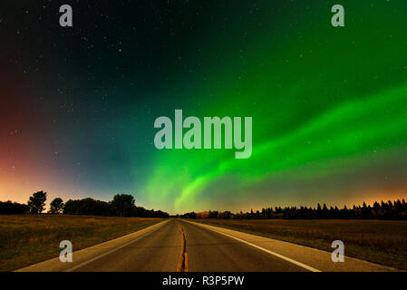 Kanada, Manitoba, Birds Hill Provincial Park. Aurora borealis und Straße. Stockfoto