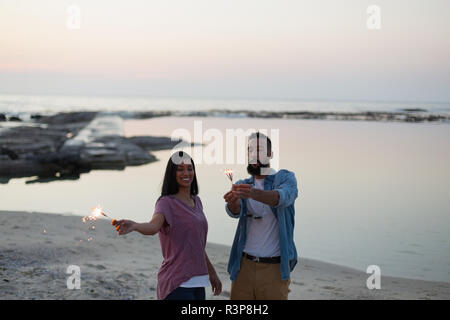 Paar, das Spaß am Strand in der Nähe von Meer Stockfoto