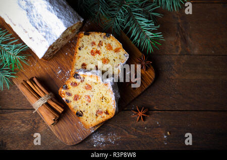 Obst Brot Kuchen mit Puderzucker bestäubt, Weihnachten und Winter Urlaub gönnen, hausgemachte Kuchen mit Rosinen auf hölzernen Hintergrund Stockfoto