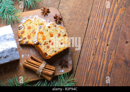 Obst Brot Kuchen mit Puderzucker bestäubt, Weihnachten und Winter Urlaub gönnen, hausgemachte Kuchen mit Rosinen auf hölzernen Hintergrund Stockfoto