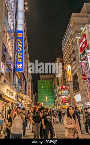 Touristen in einem Stadtbild in Chuo Dori in Akihabara bei Sonnenaufgang, Tokio, Japan Stockfoto