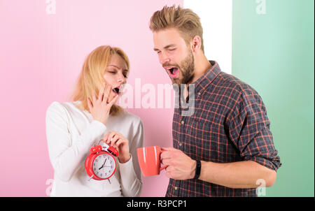 Wir sollten gehen Sie früher ins Bett. Frau und Mann sleepy zerzaustem Haar trinken Kaffee am Morgen. Leider spät Regime. Paar Morgen erwachen Wecker. Erstellen Stockfoto