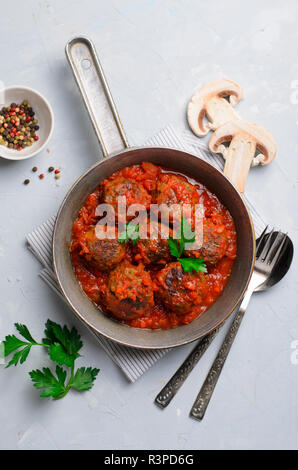 Frikadellen in Tomatensoße in einer Pfanne auf einem hellen Hintergrund, leckere hausgemachte Speisen Stockfoto