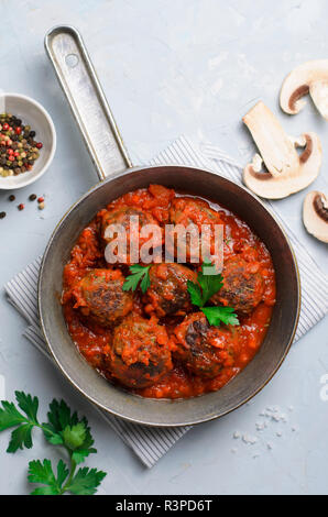 Frikadellen in Tomatensoße in einer Pfanne auf einem hellen Hintergrund, leckere hausgemachte Speisen Stockfoto
