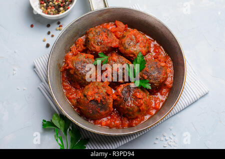 Frikadellen in Tomatensoße in einer Pfanne auf einem hellen Hintergrund, leckere hausgemachte Speisen Stockfoto