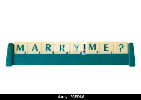 Scrabble-Spiel Buchstabensteine mit Score Wert auf Stativ, die die Phrase "Heirate mich?'. Auf weissem Hintergrund. Stockfoto