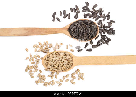Geschälte und ungeschälte Körner in einem hölzernen Löffel auf weißem Hintergrund. Ansicht von oben Stockfoto