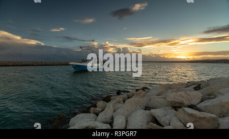 Ein Fischerboot zurück zum Hafen bei Sonnenuntergang in Spanien. Stockfoto