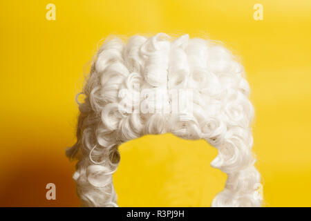 Weiße Perücke auf gelbem Hintergrund beurteilen. Stockfoto