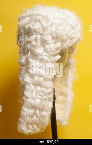 Weiße Perücke auf gelbem Hintergrund beurteilen. Stockfoto