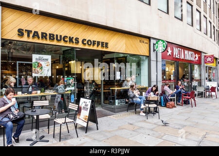 City of London England, Vereinigtes Königreich Großbritannien, Großbritannien, Großbritannien, Großbritannien, Großbritannien, Großbritannien, Starbucks Coffee, amerikanische Kaffeehauskette, Café, Sitzgelegenheiten auf dem Bürgersteig, Außenansicht, Tische, Erwachsene Stockfoto