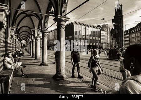 Marktplatz, Bremen. Deutschland. Deutschland. Ein Blick vom Rathaus auf den Marktplatz. Unter den Arkaden des Rathauses, Rathaus fotografiert, mit der Menschen vorbei. Es ist eine helle, sonnige Nachmittag und die starke Sonneneinstrahlung ist Casting starke Schatten Drama, um die Szene hinzuzufügen. Stockfoto